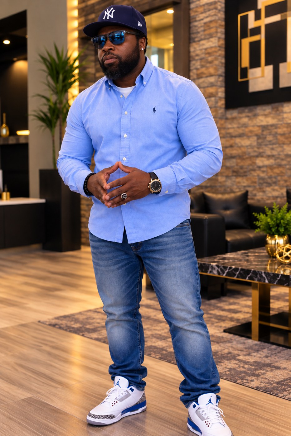 Nigel Thomas in a modern lobby, wearing a Yankees cap and sunglasses